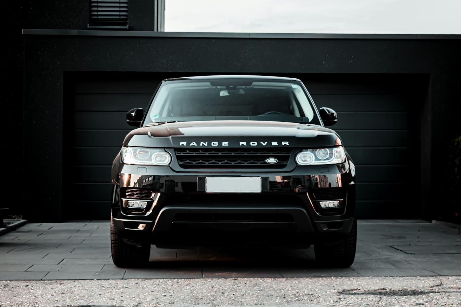 Black luxury SUV with mirror-like paint on a driveway